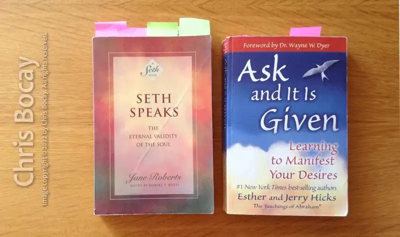 A photograph of two books with the authorized version of Law of Attraction: 'Seth Speaks' by Seth, and 'Ask and It Is Given' by Abraham-Hicks.